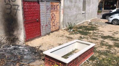 Boş bir arazide görülen ve üzerinde isimli taşı bulunan mezar,