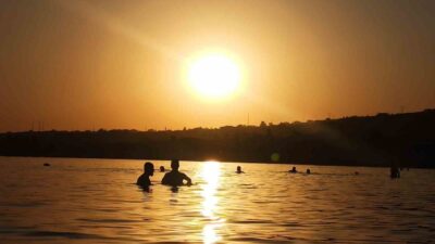 Bitlis’in Ahlat ilçesinde vatandaşlar, gün batımında Van Gölü’nde yüzmenin keyfini